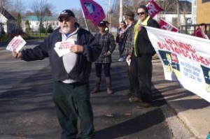 A CUPE member holds out flyers about the province's paving plant that they say government plans to close down.